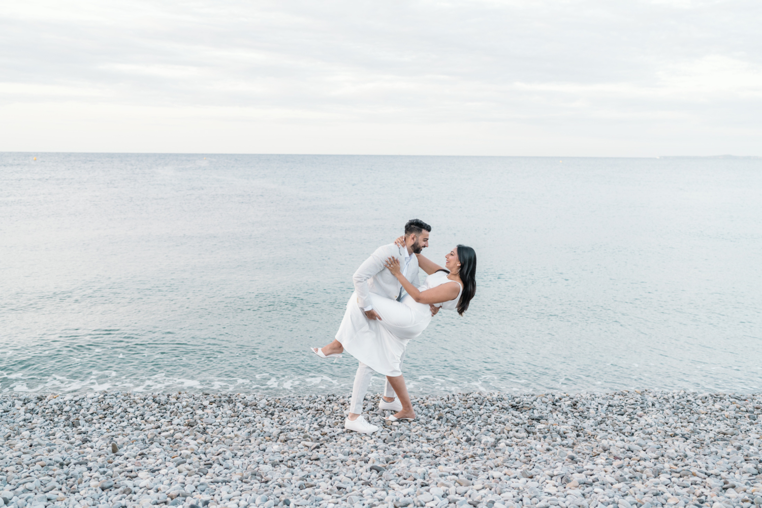 man dips woman backward on the beach in old town nice