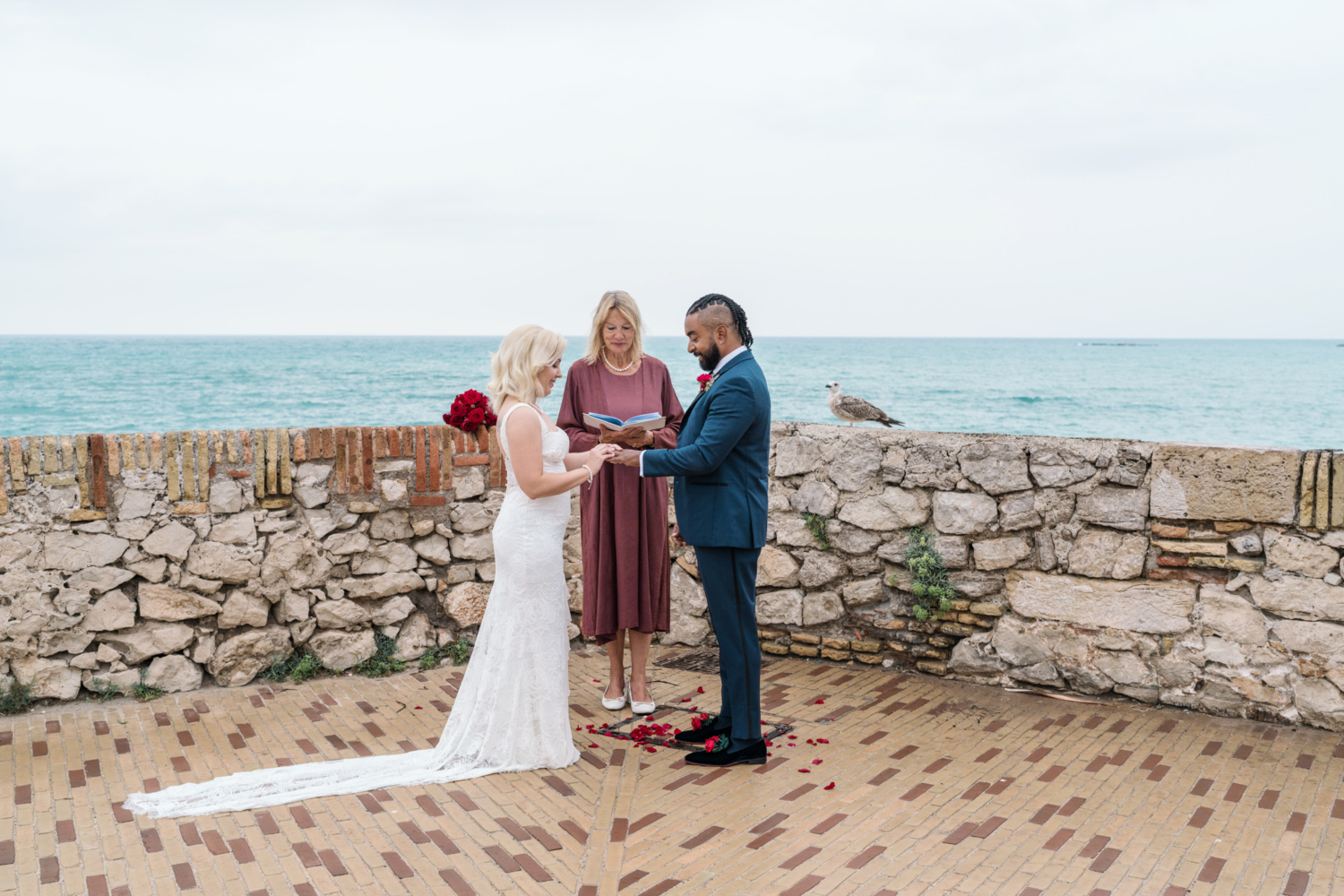 bride places ring on grooms finger during ceremony in antibes france