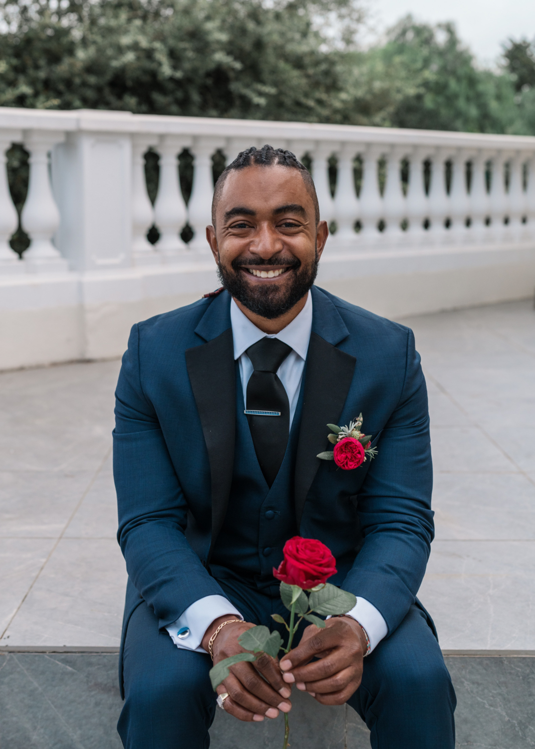 groom smiles holding a rose on his wedding day in antibes france