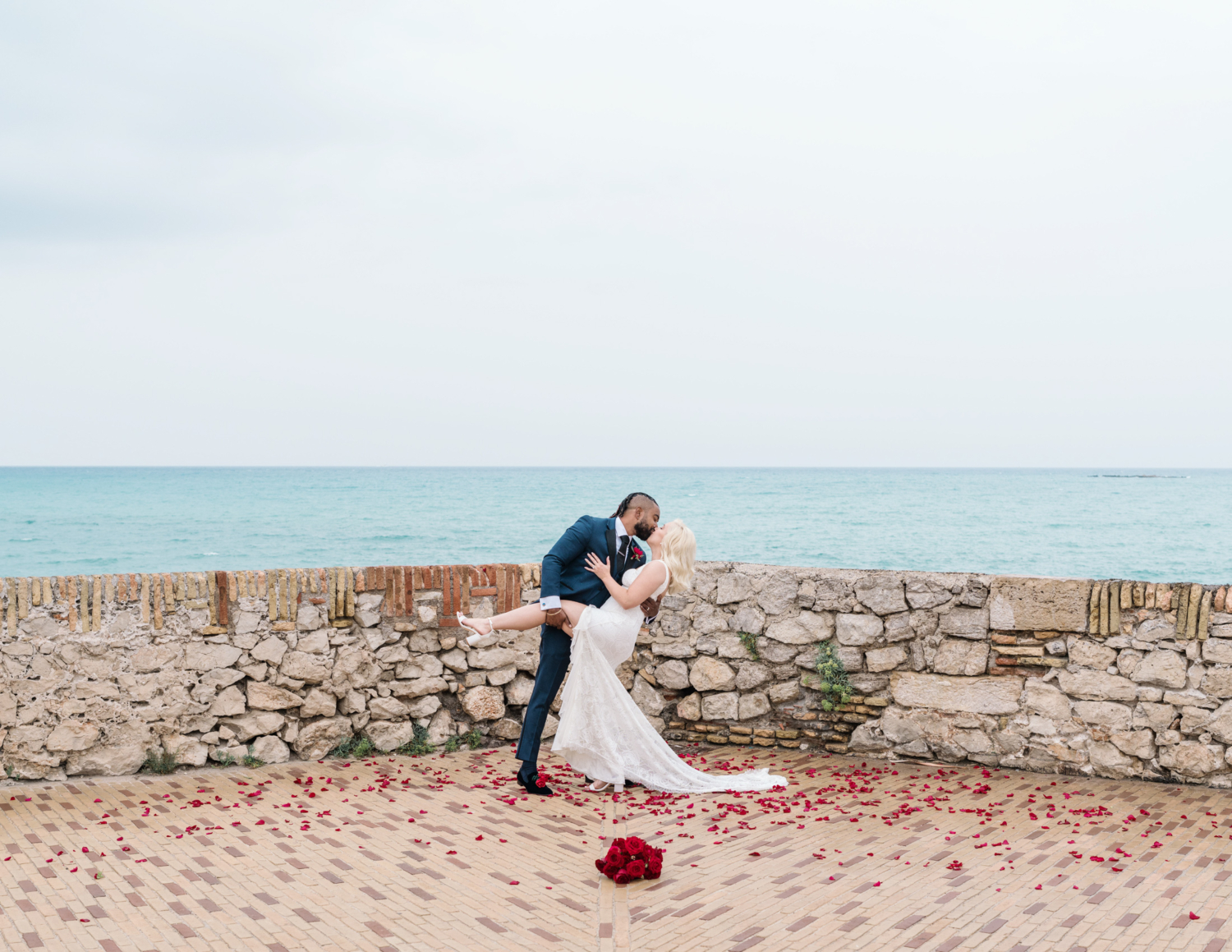 groom dips new bride with view of sea in antibes france