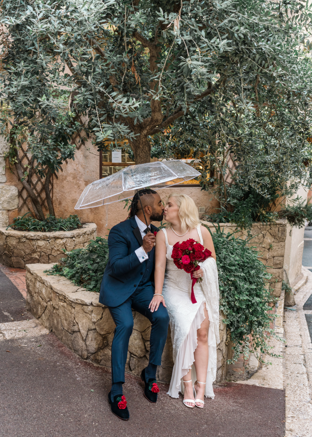 bride and groom kiss under umbrella in antibes france