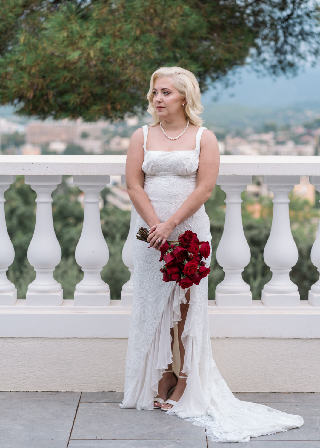 bride poses on her wedding day with bouquet of roses in antibes france