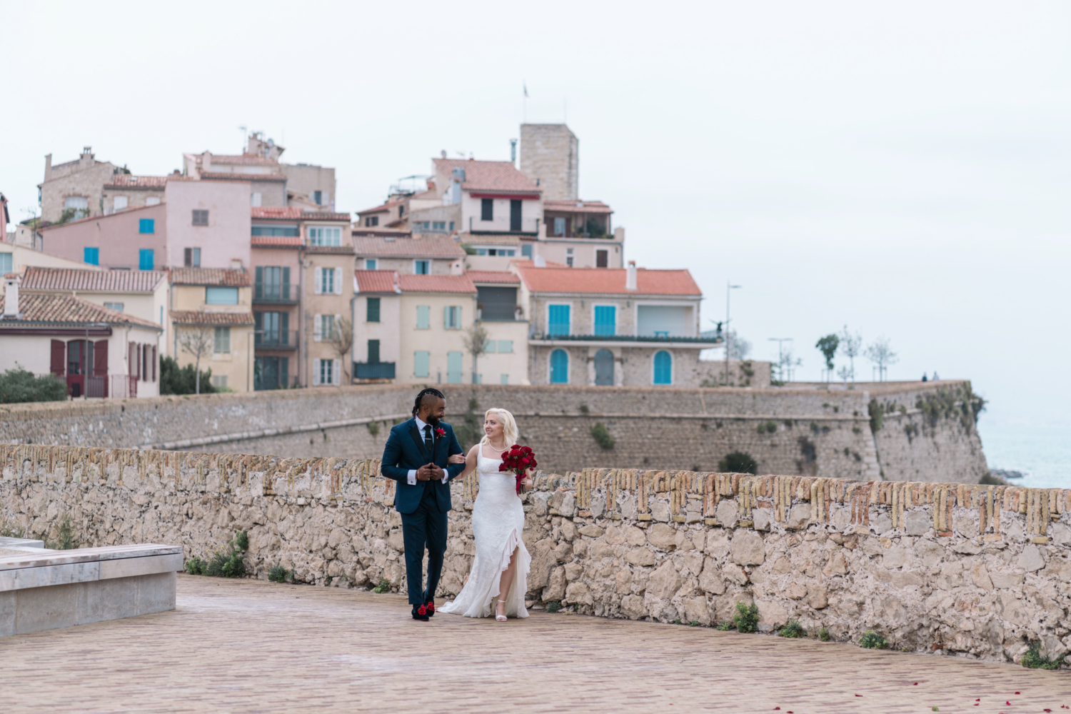 bride and groom walk arm and arm in antibes france