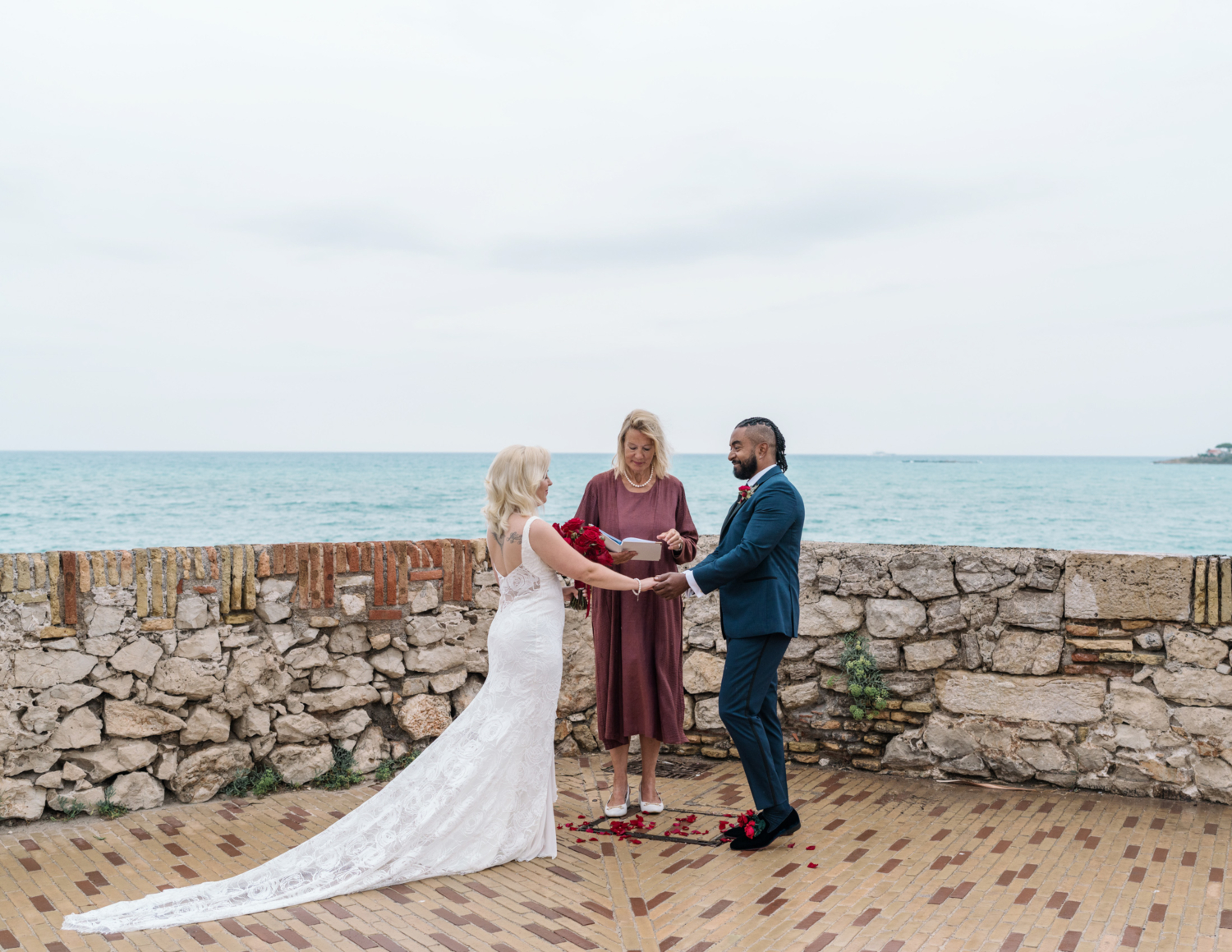 bride and groom hold hands in wedding ceremony in antibes france