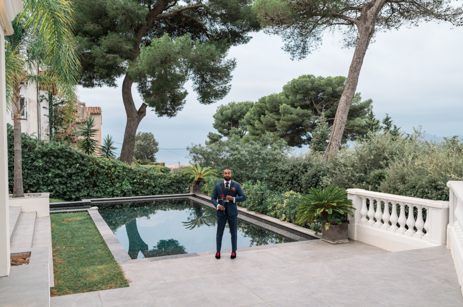 groom hold roses and waits by pool for bride in antibes france