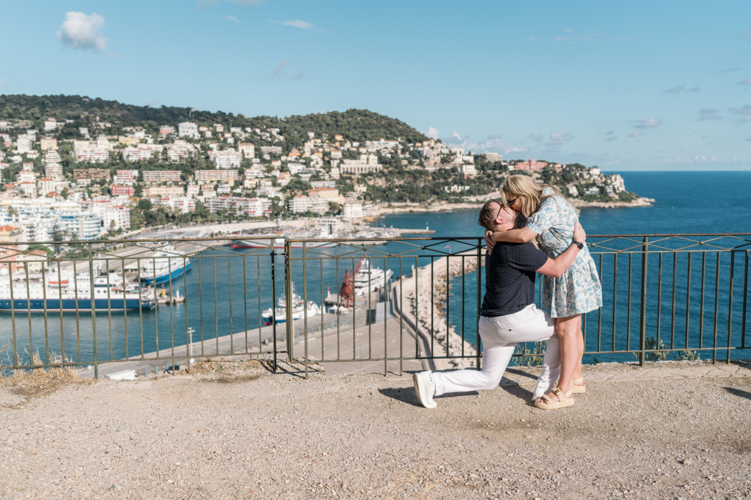 couple embrace after surprise proposal with view of sea in nice france