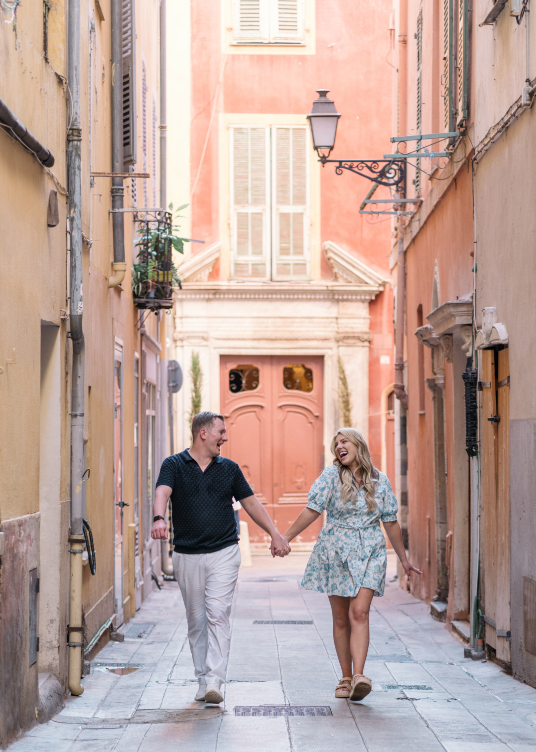 newly engaged couple laugh and walk in old town nice