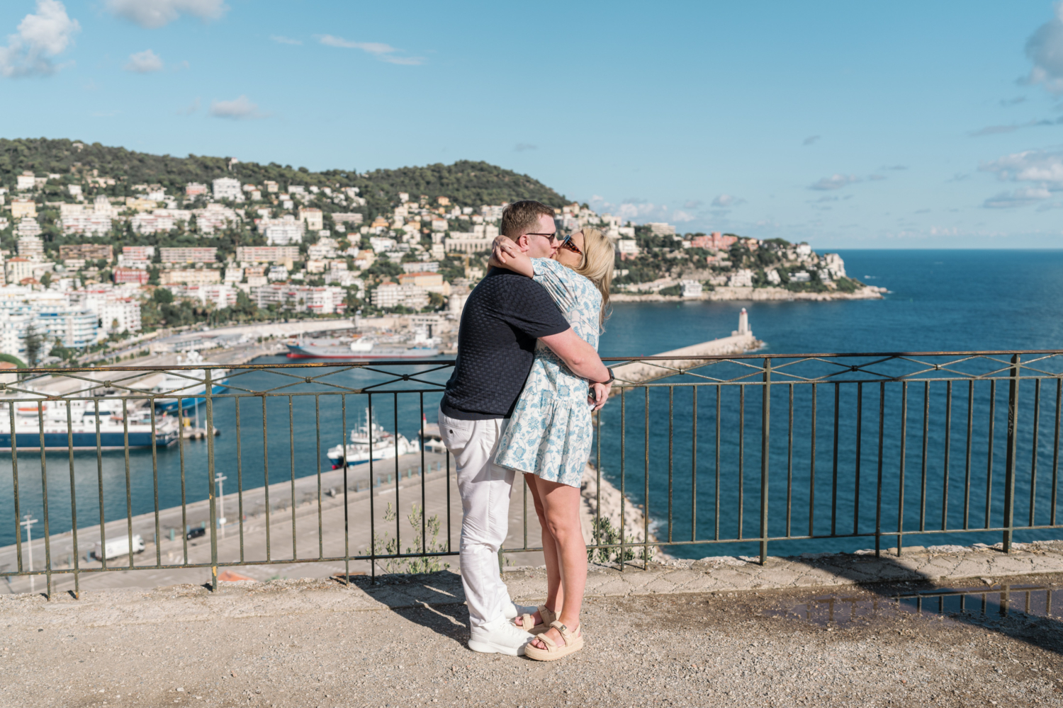 woman hugs man after surprise proposal with view of sea in nice france