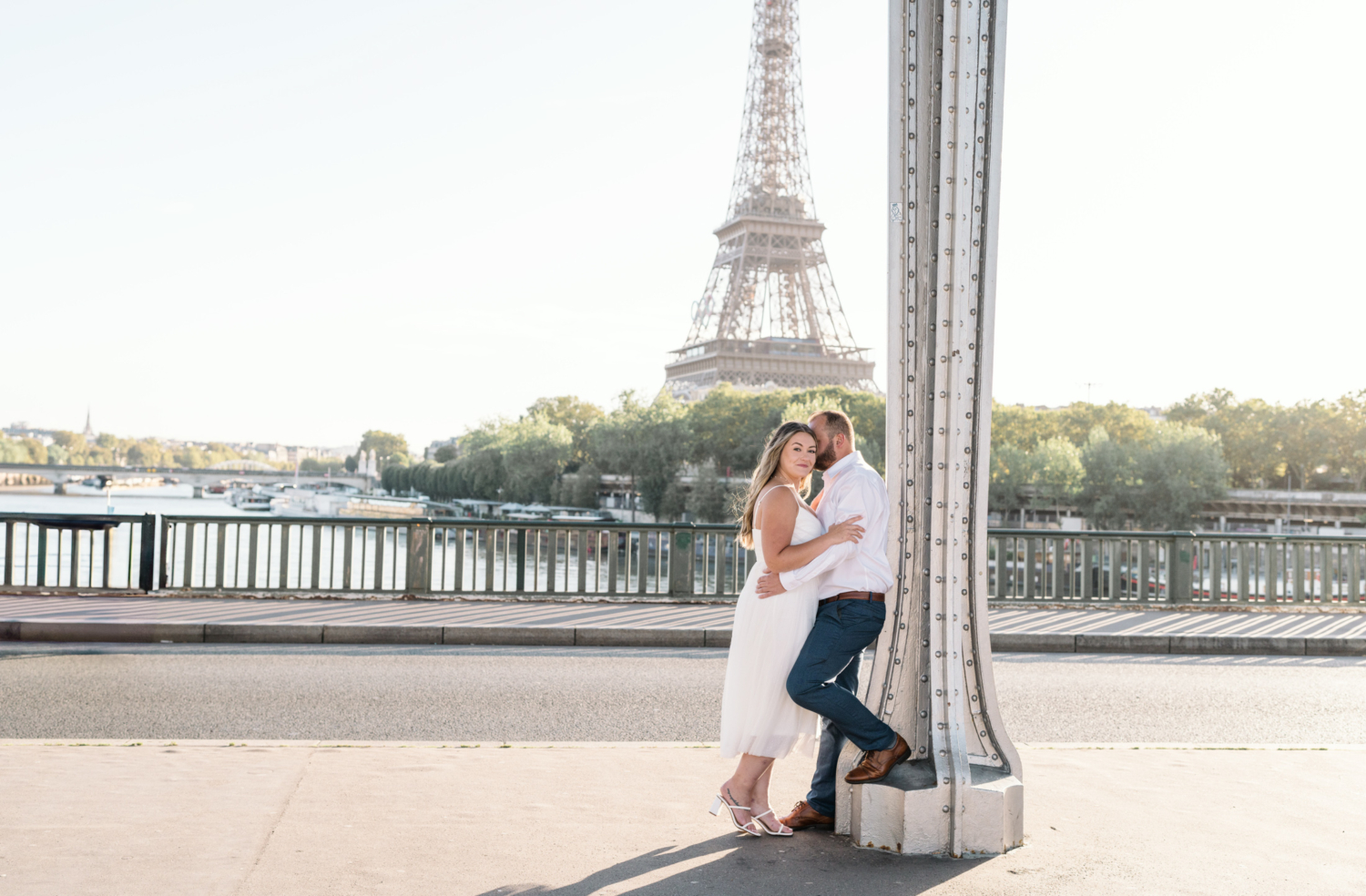 engaged couple embrace with view of the eiffel tower in paris