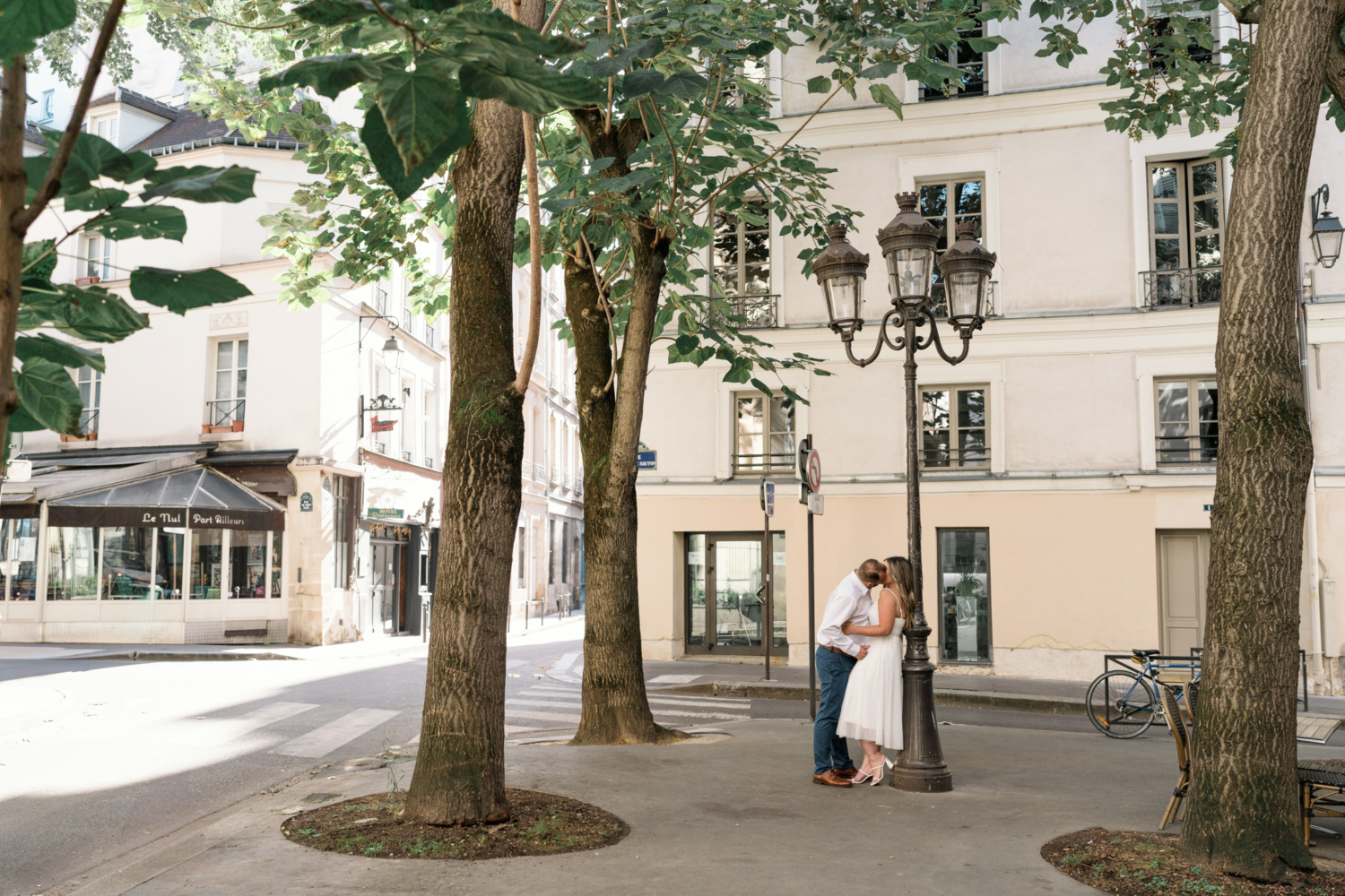 couple kiss passionately in the latin quarter in paris france under a lightpost