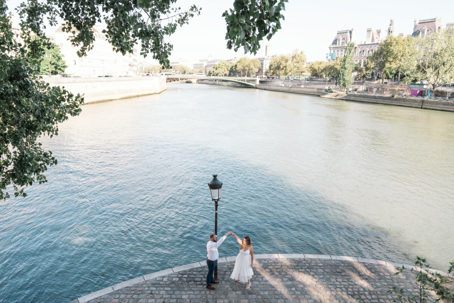 engaged couple dance with view of paris and seine river