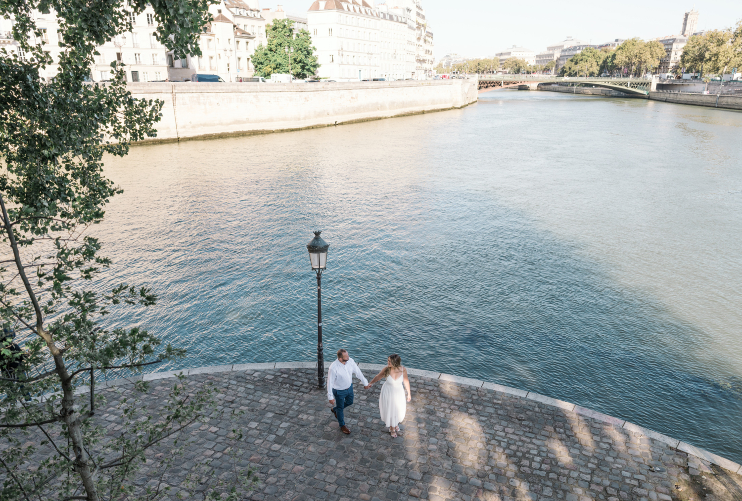 engaged couple walk along river in charming paris frace