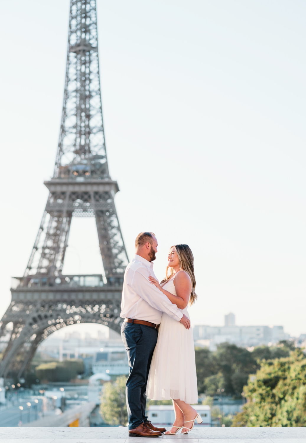 in love couple pose in front of eiffel tower in paris