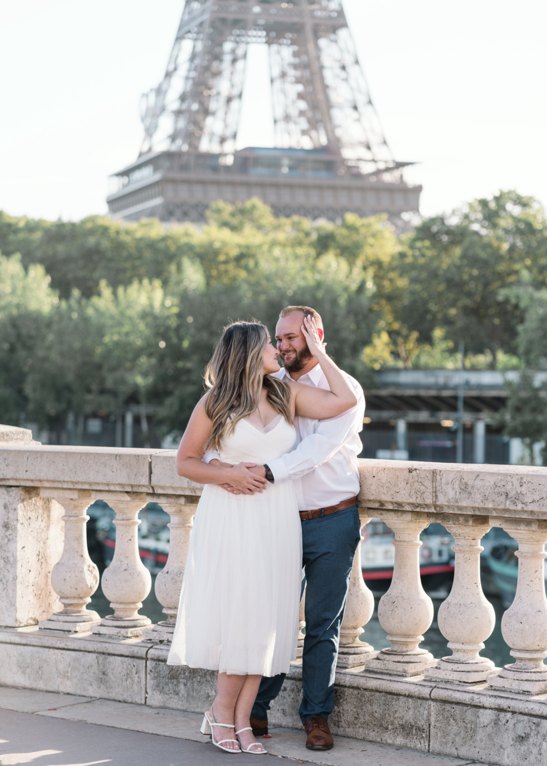 woman embraces man as they pose with eiffel tower behind them