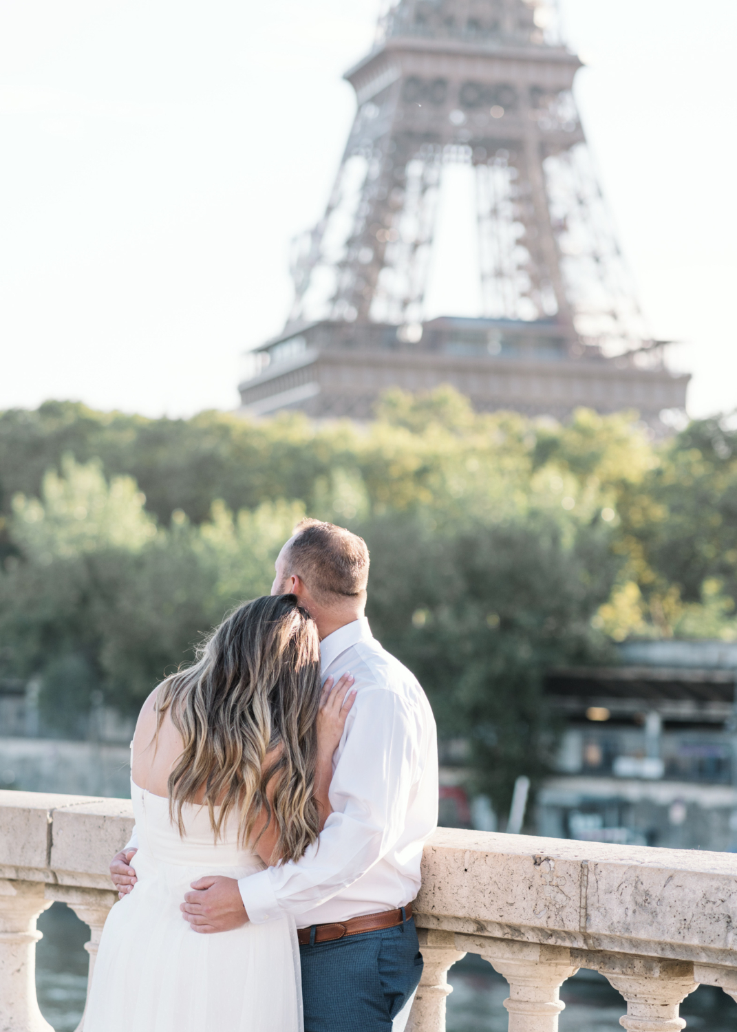 woman lays head on man as they look at the eiffel tower in paris