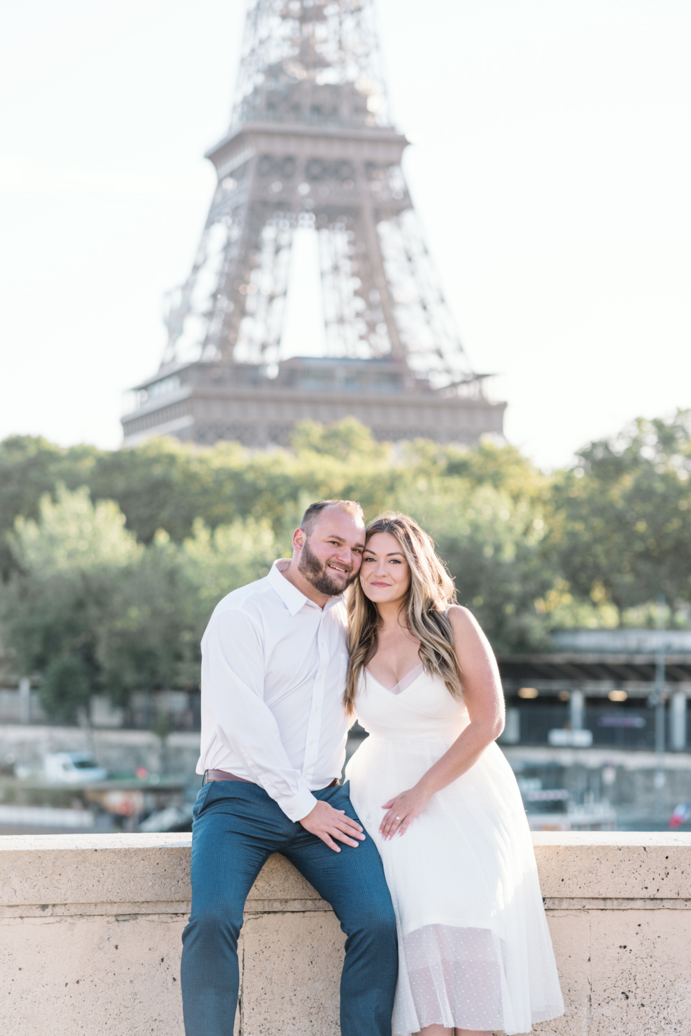 cute couple pose cheek to cheek with eiffel tower behind them