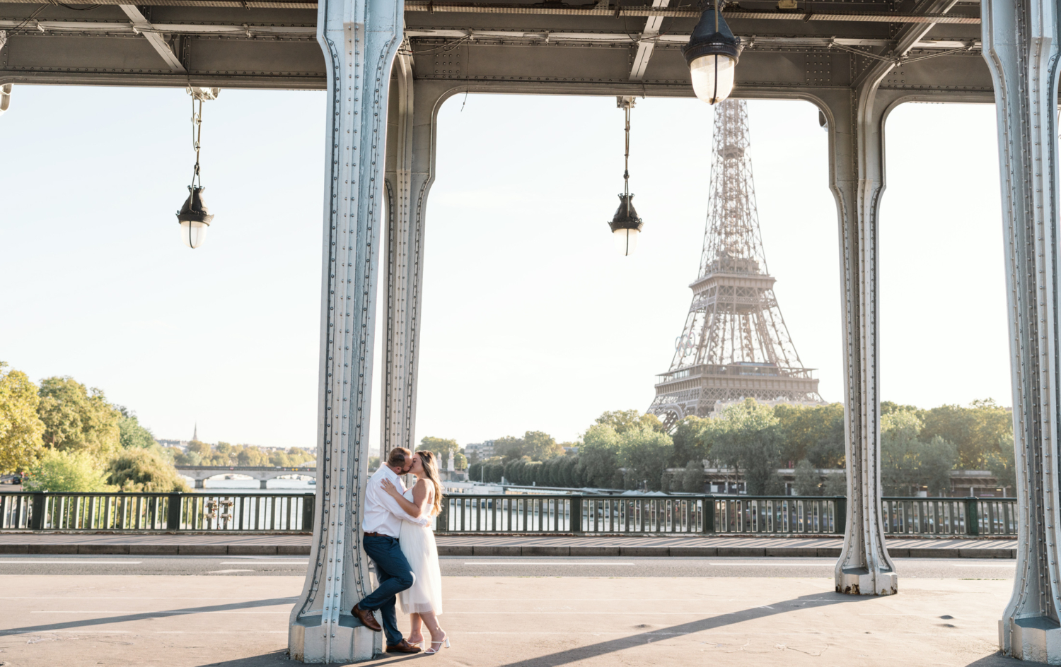 engaged couple kiss under bir hakeim bridge in paris france