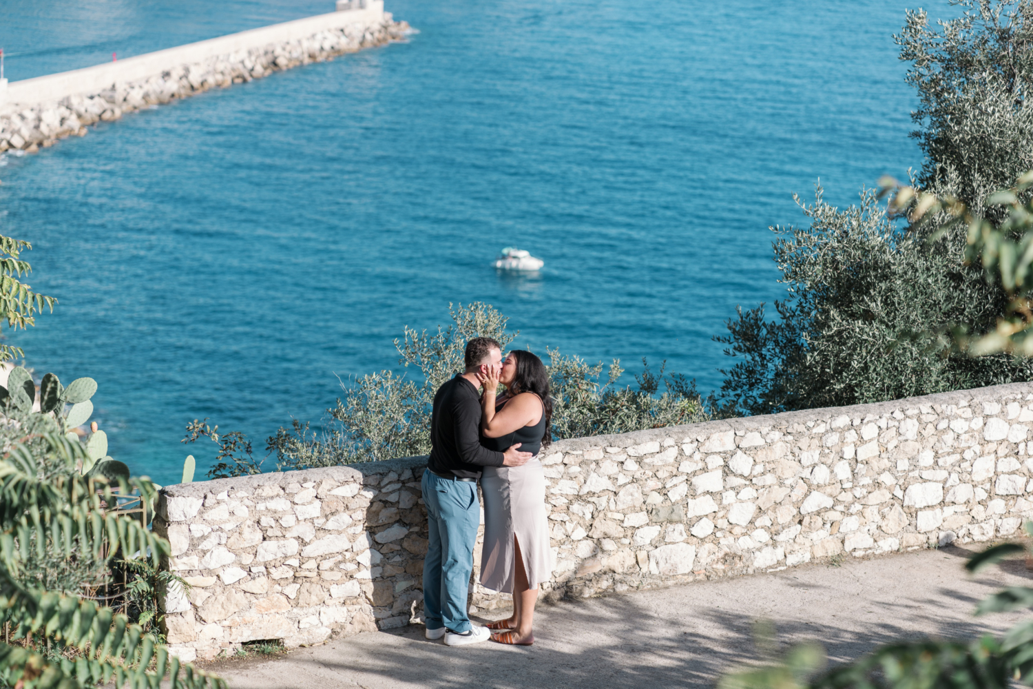 man and woman kiss passionately with view of sea in background in nice france