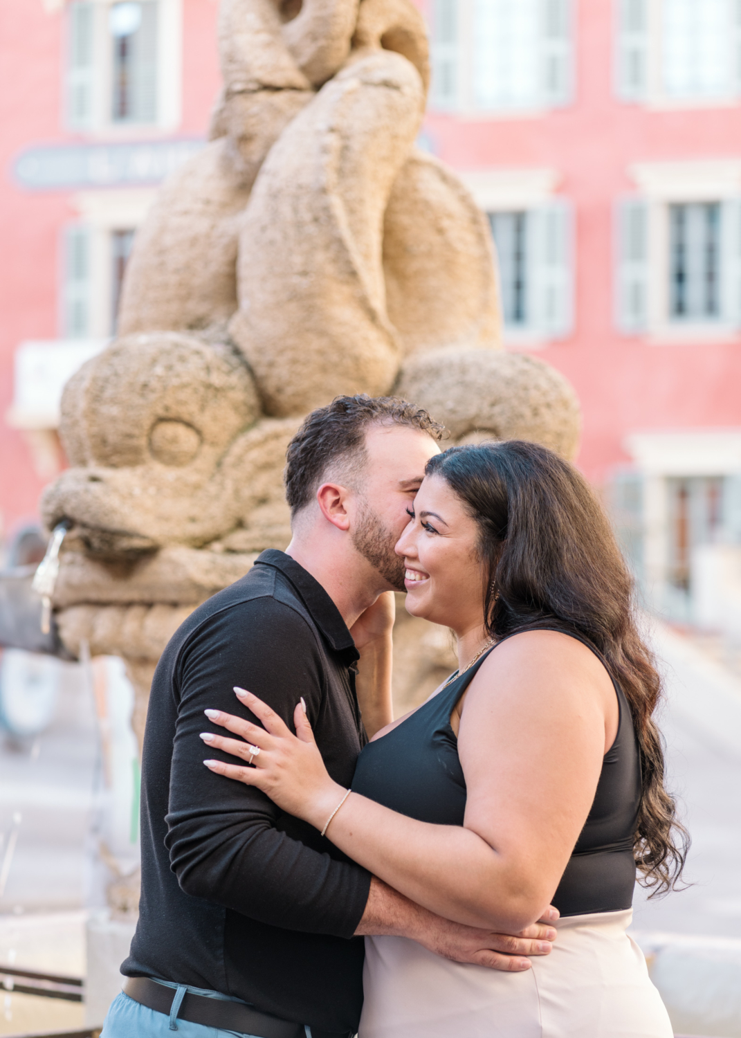 man tells woman a secret next to fountain in nice france