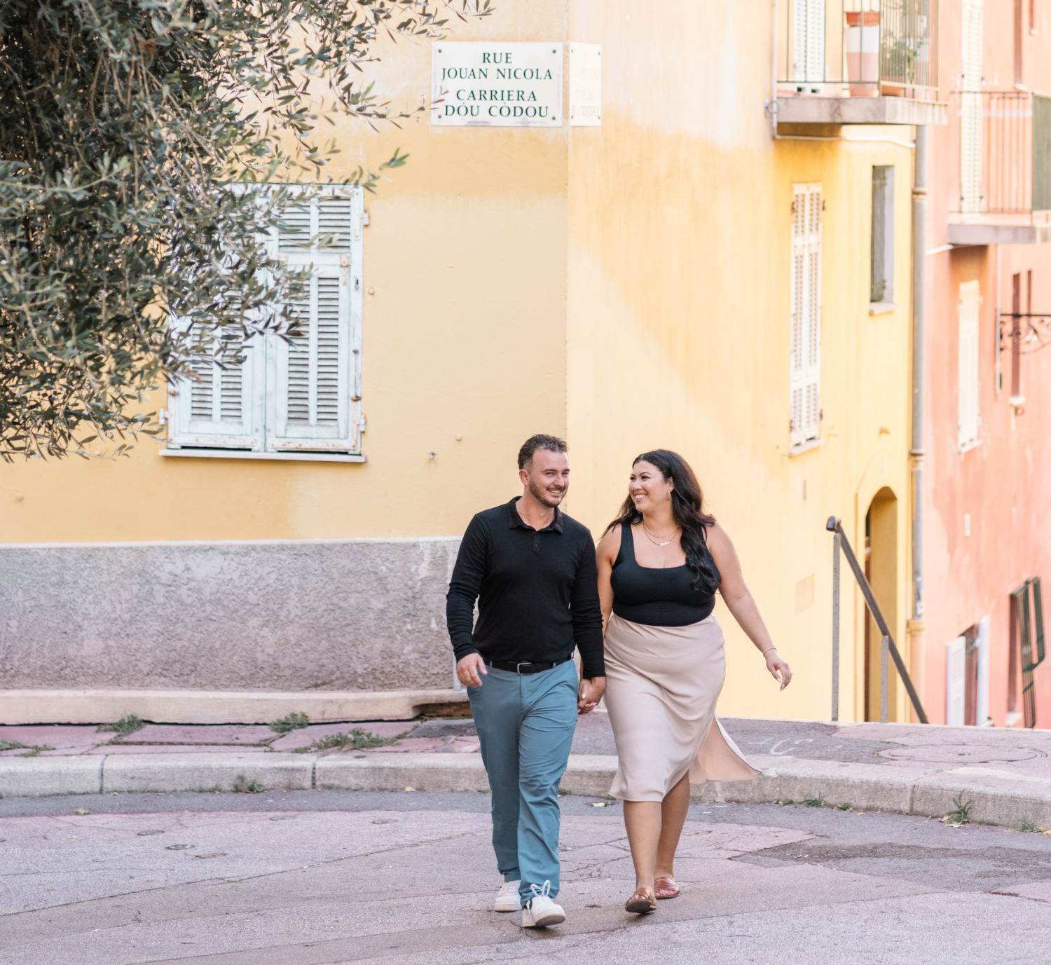 newly engaged couple in nice france smile as they walk colorful street