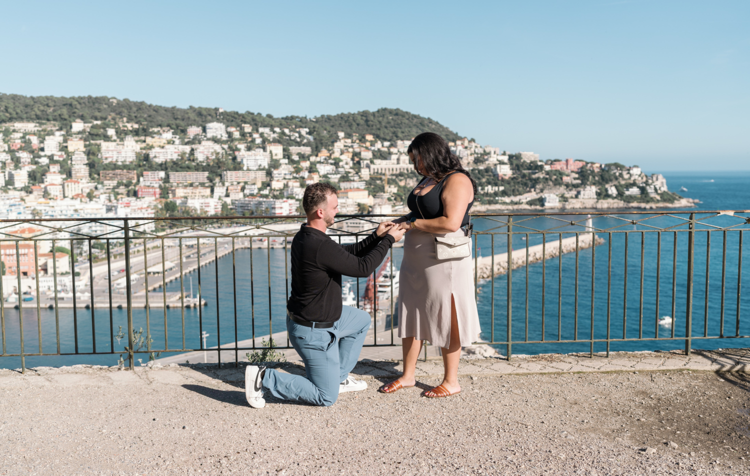 man slips engagement ring on woman's finger in nice france