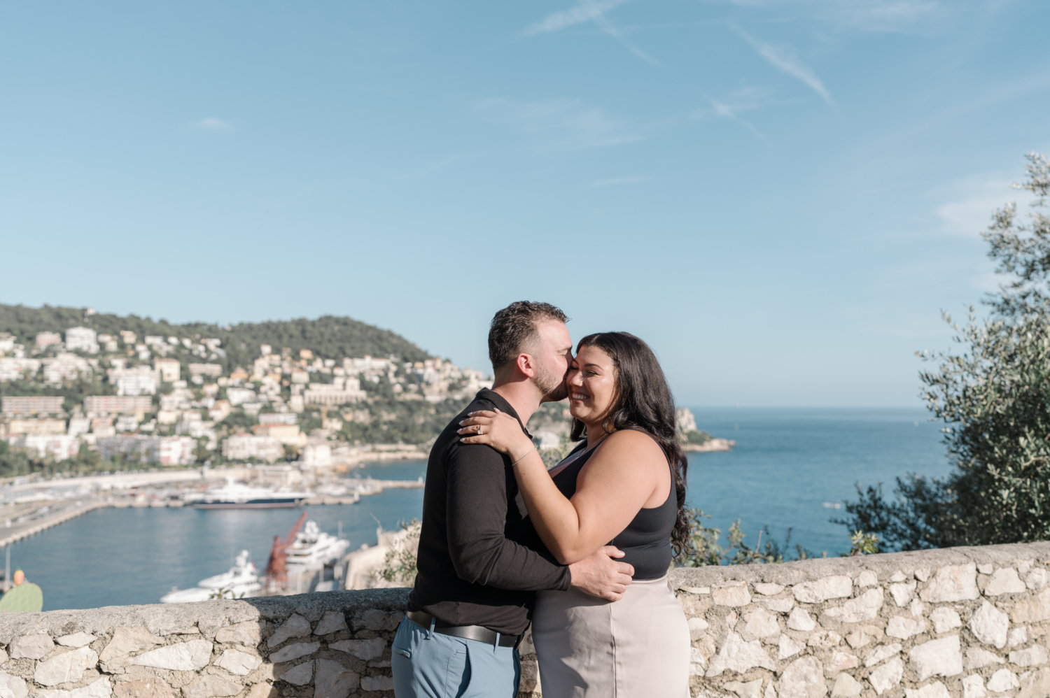 man kisses fiance on cheek with view of the sea in nice france