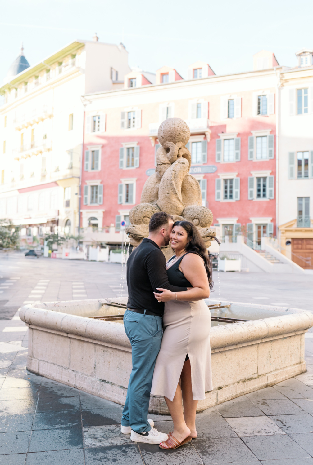 newly engaged couple pose in front of fountain in old in nice france