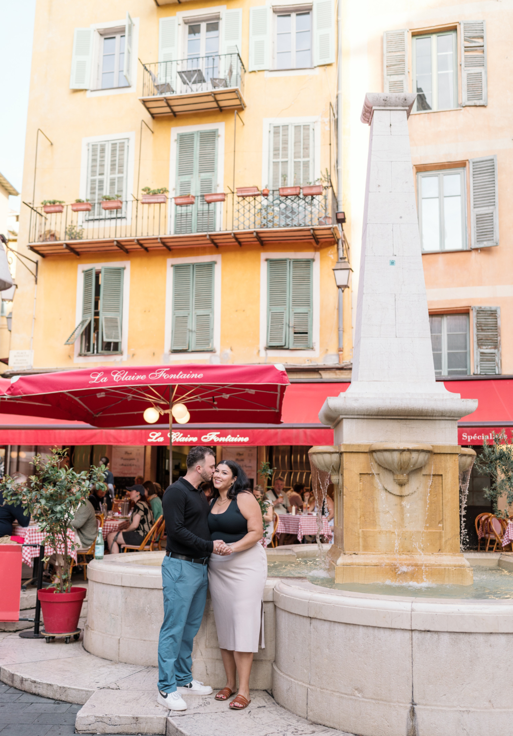 newly engaged couple kiss next to fountain in nice france