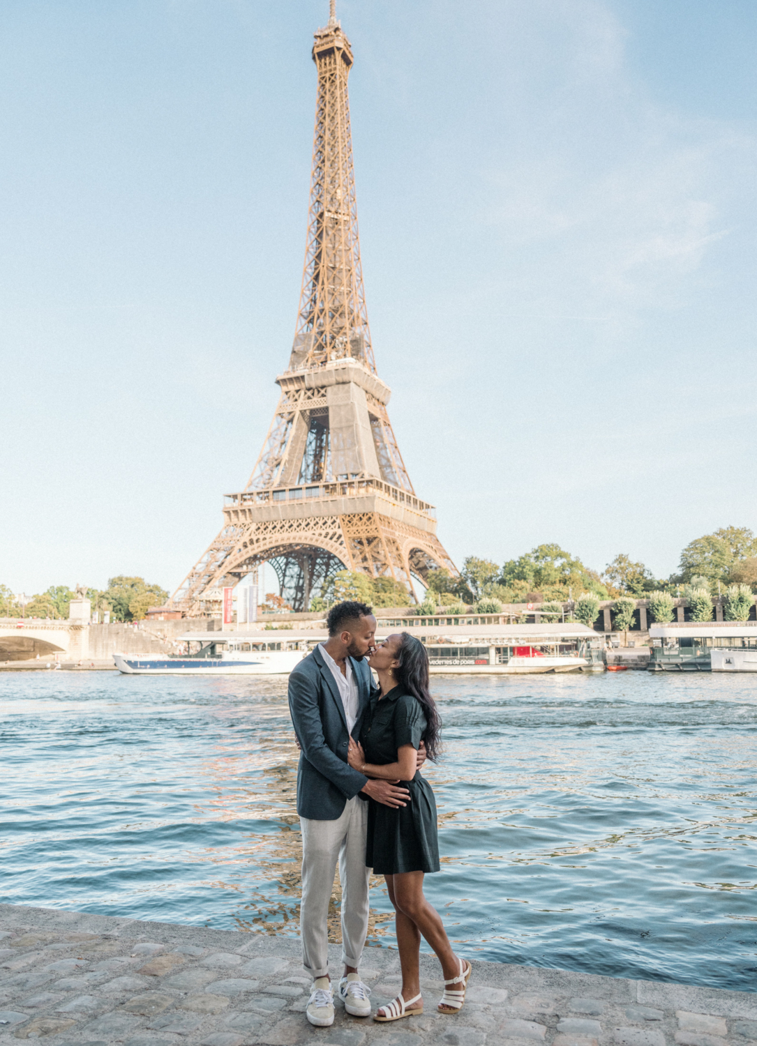 newly engaged african american couple kiss in front of the eiffel tower