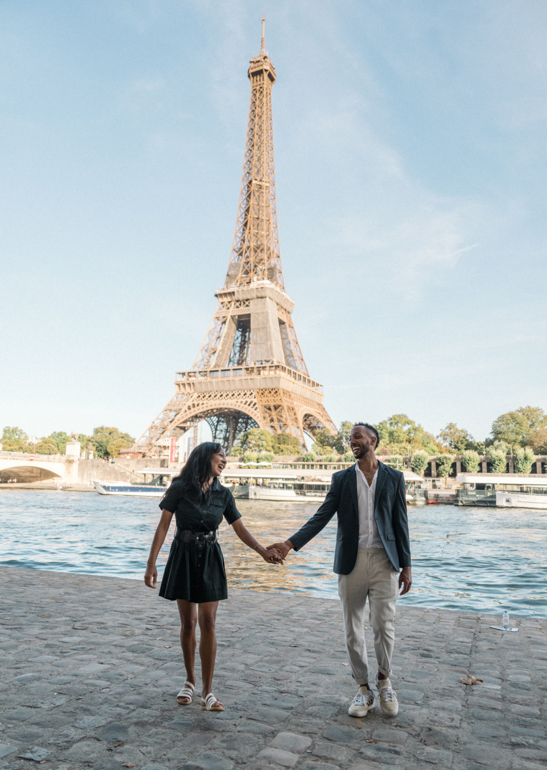 newly engaged african american couple laugh in paris with view of eiffel tower