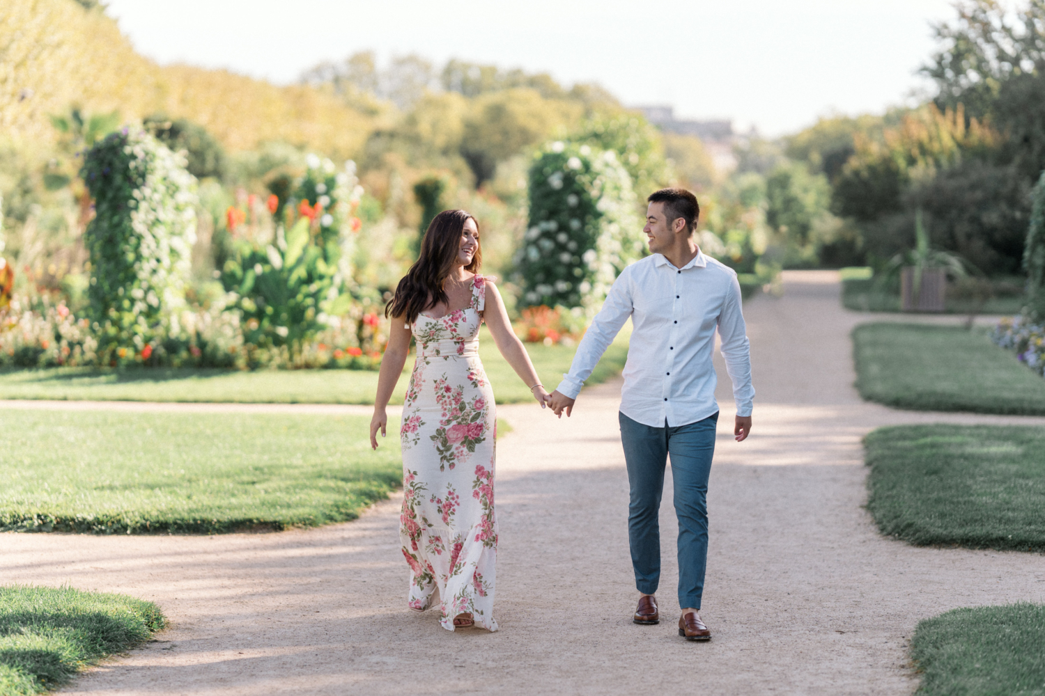 engaged couple walk hand in hand through jardin des plantes in paris