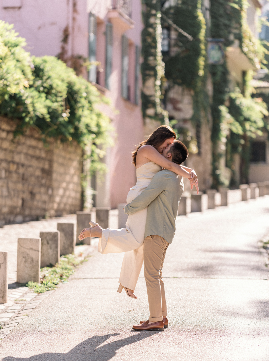 man lifts woman in air and kisses her in montmartre paris