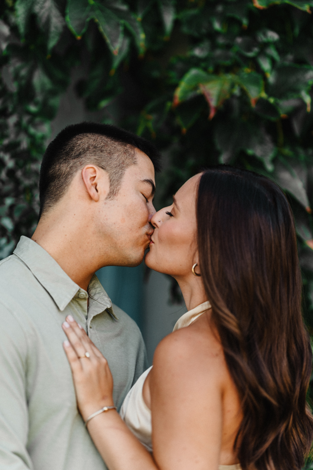 engaged couple kiss passionately by a tree in paris