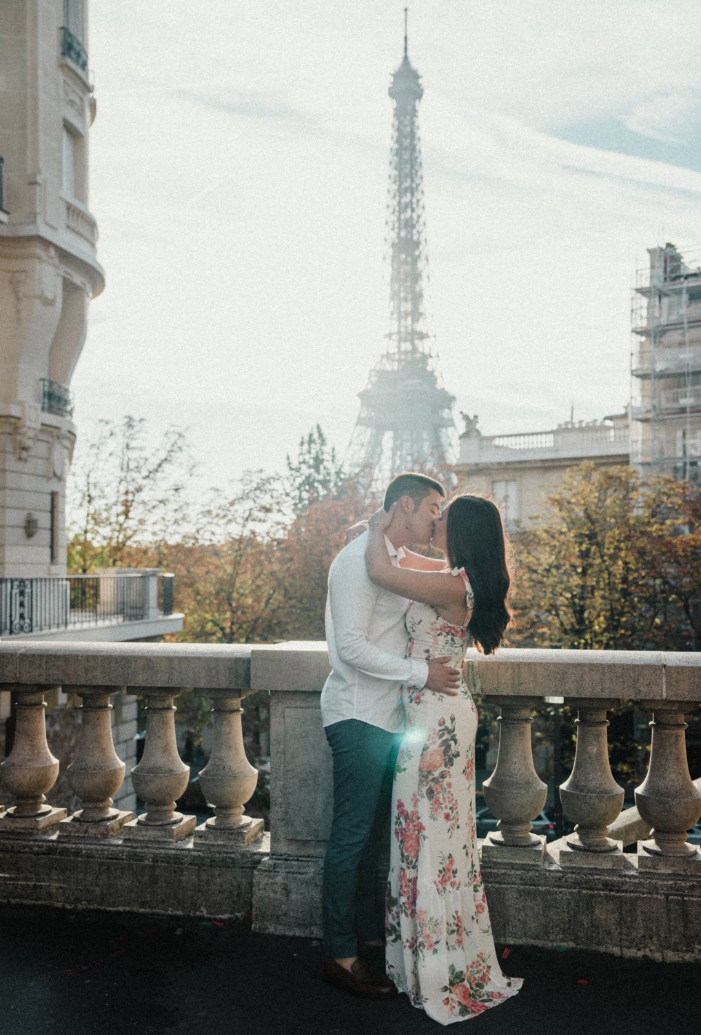 young engaged couple kiss with view of eiffel tower in paris france