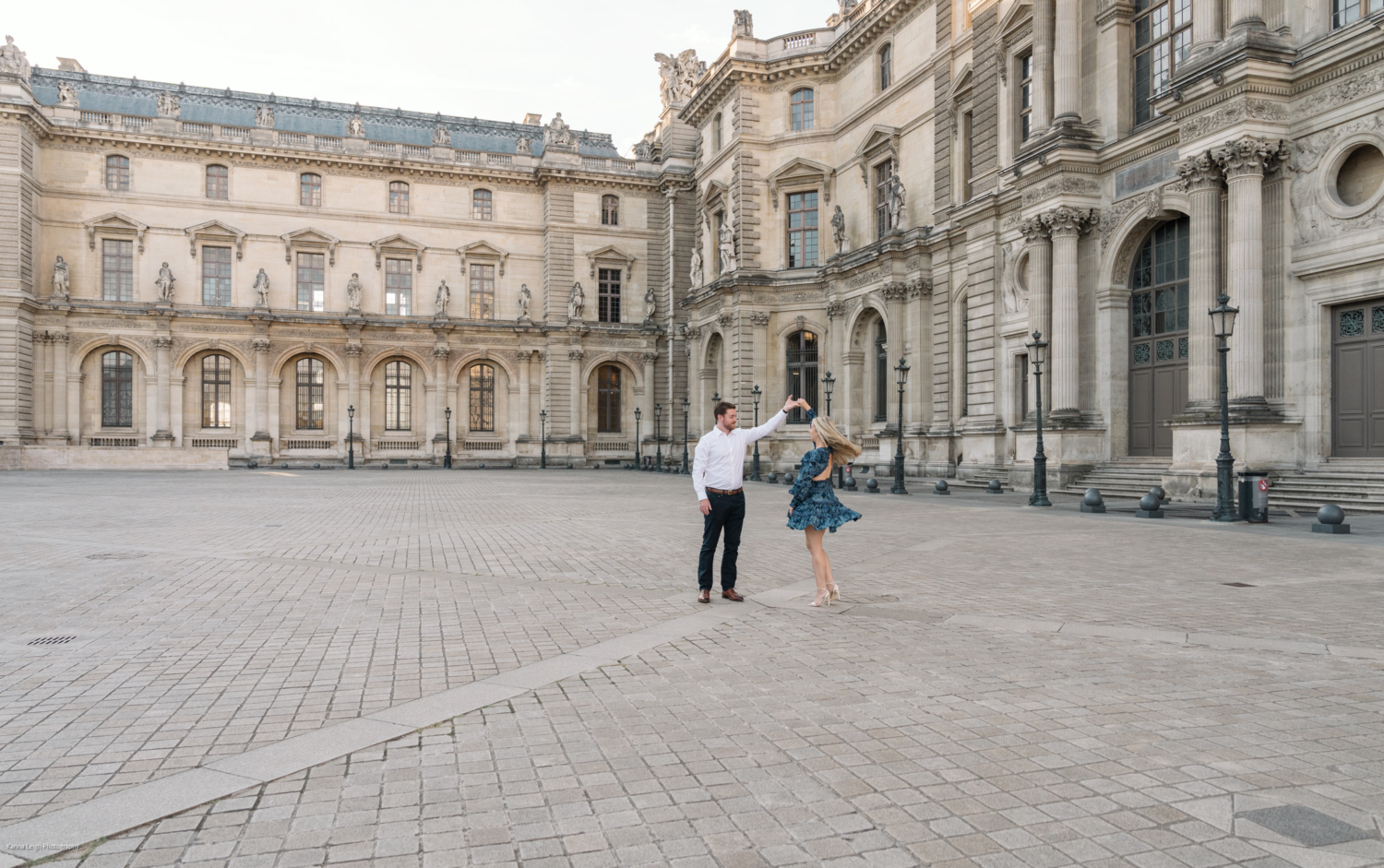 young newly engaged couple spin and dance at the louvre in paris