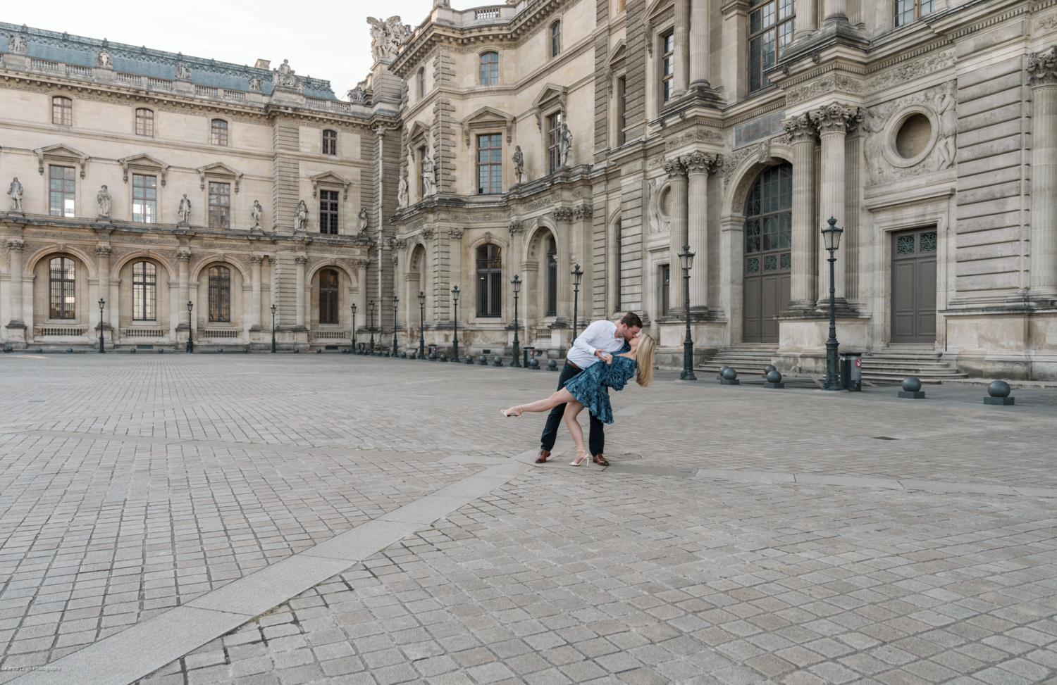 man dips woman backward as they dance at the louvre museum in paris