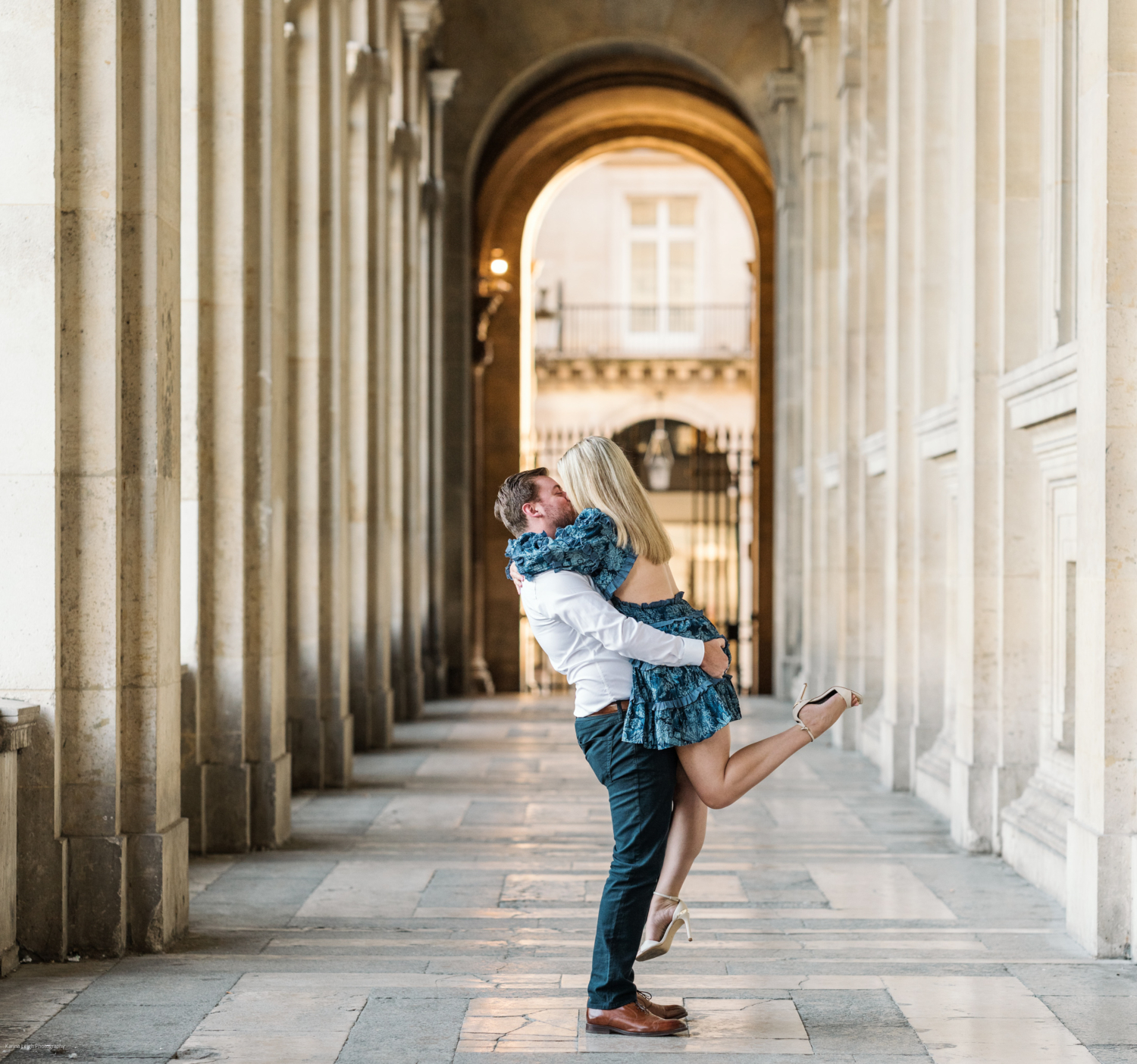 man lifts woman and kisses her at the louvre museum in paris