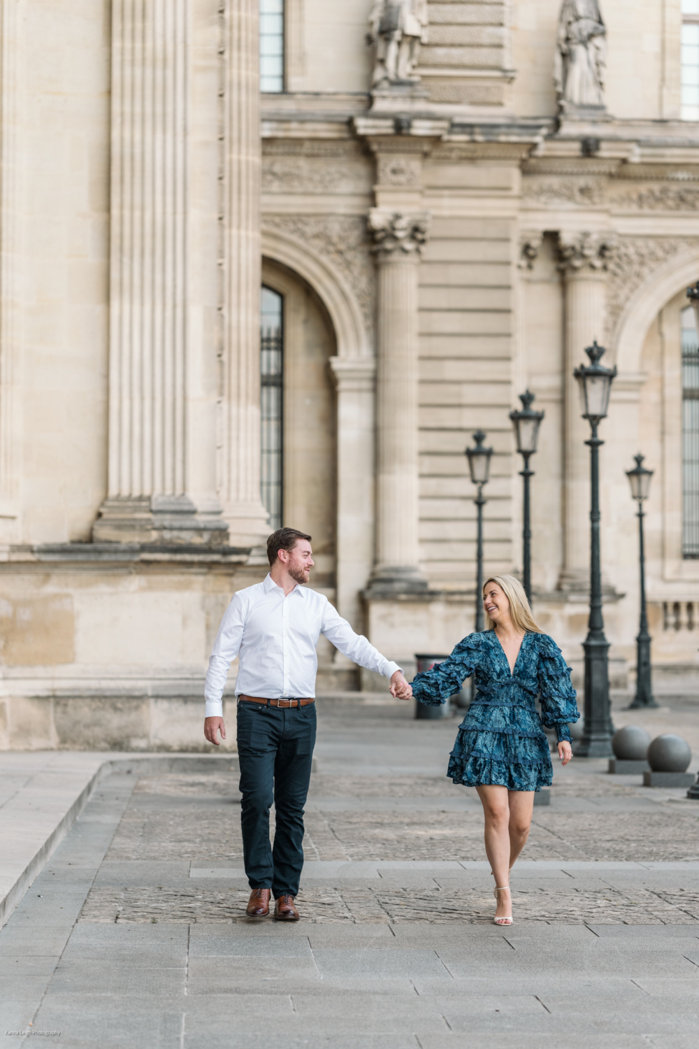 young newly engaged couple happy walk at the louvre museum  during Engagement Photos In Paris