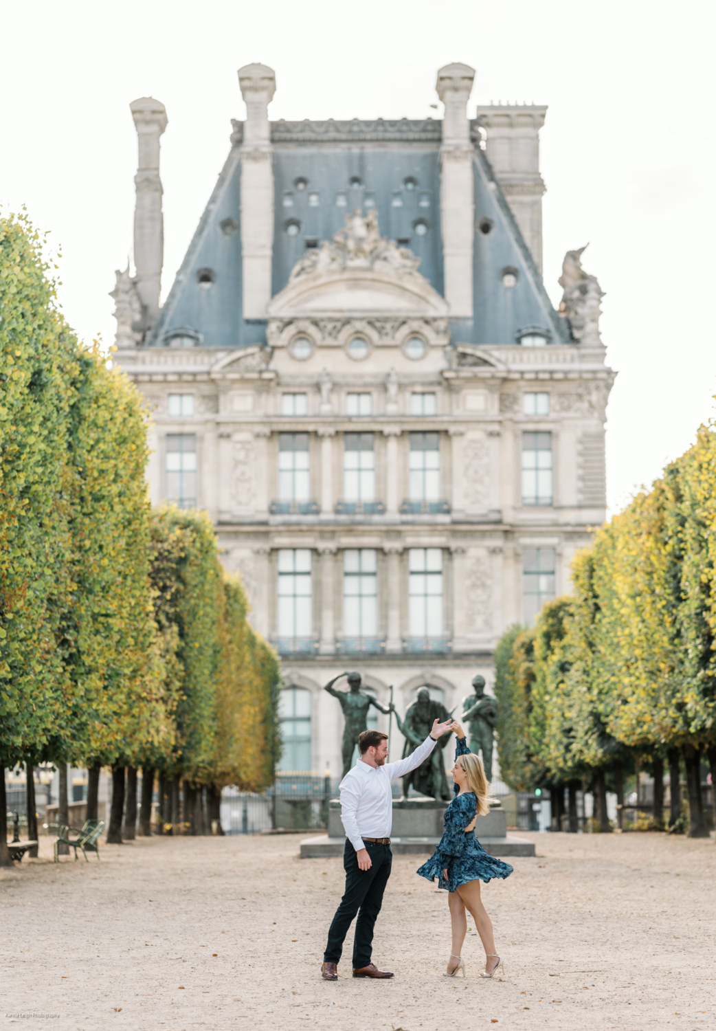 young newly engaged couple dance in the tuileries gardens in paris