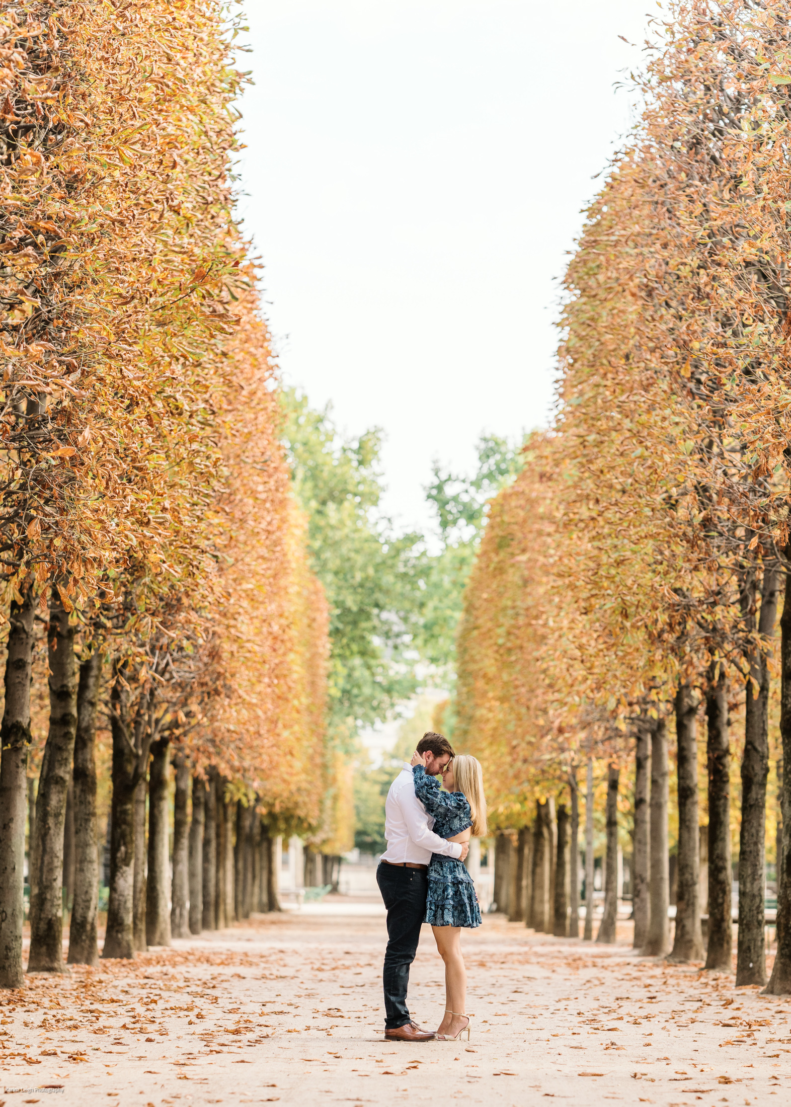 young newly engaged couple embrace in autumn in tuileries gardens