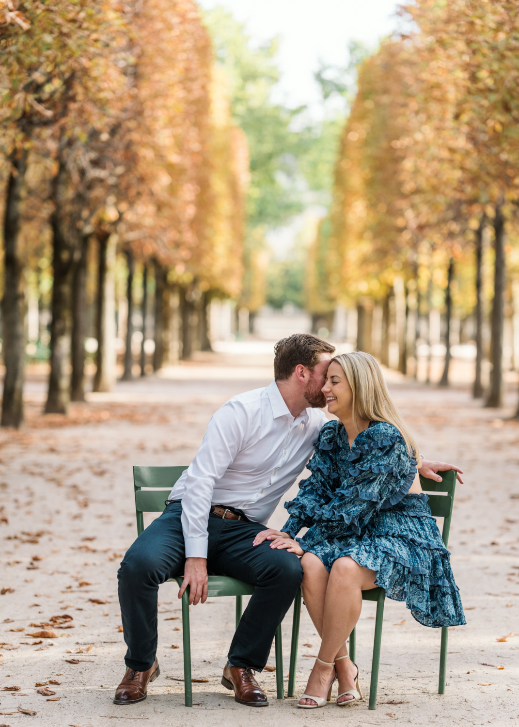 young newly engaged couple laugh in the tuileries gardens in paris