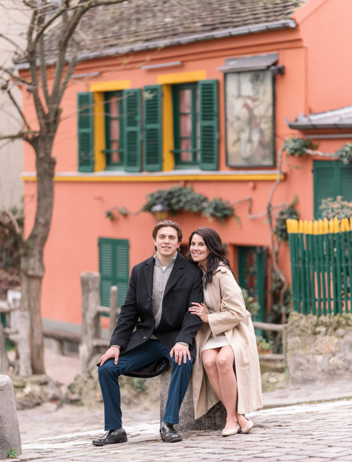 newly engaged couple pose next to charming orange cottage in paris france