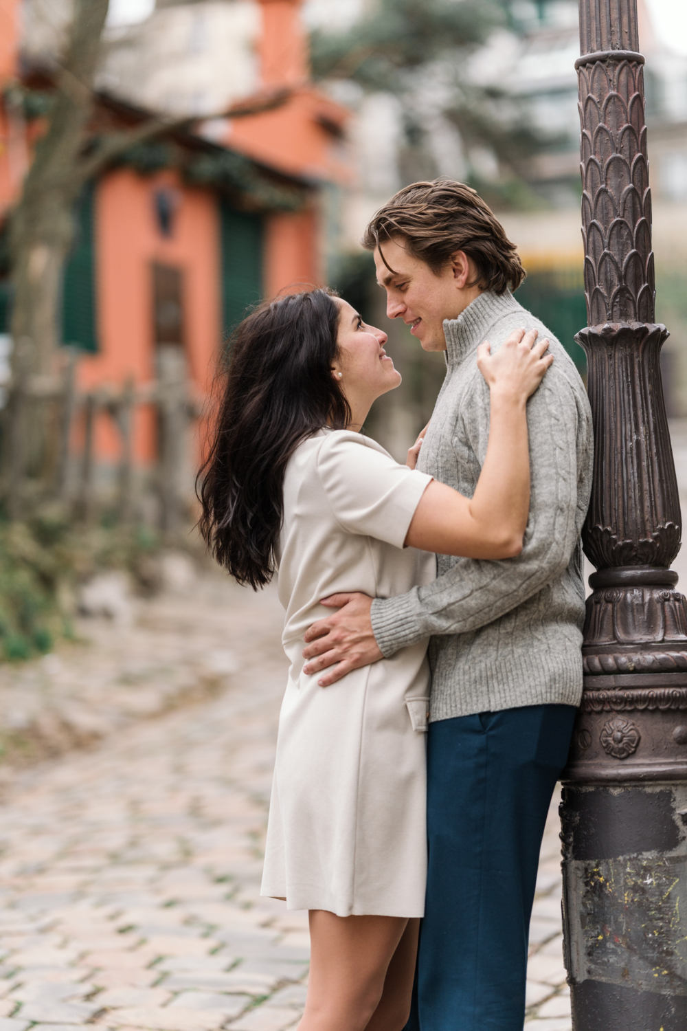 newly engaged couple embrace in charming neighborhood in paris france