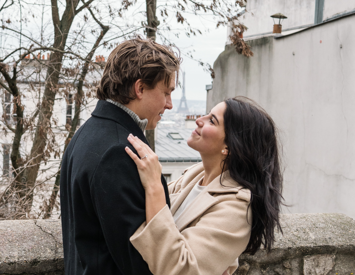 newly engaged couple look at each other with eiffel tower in background