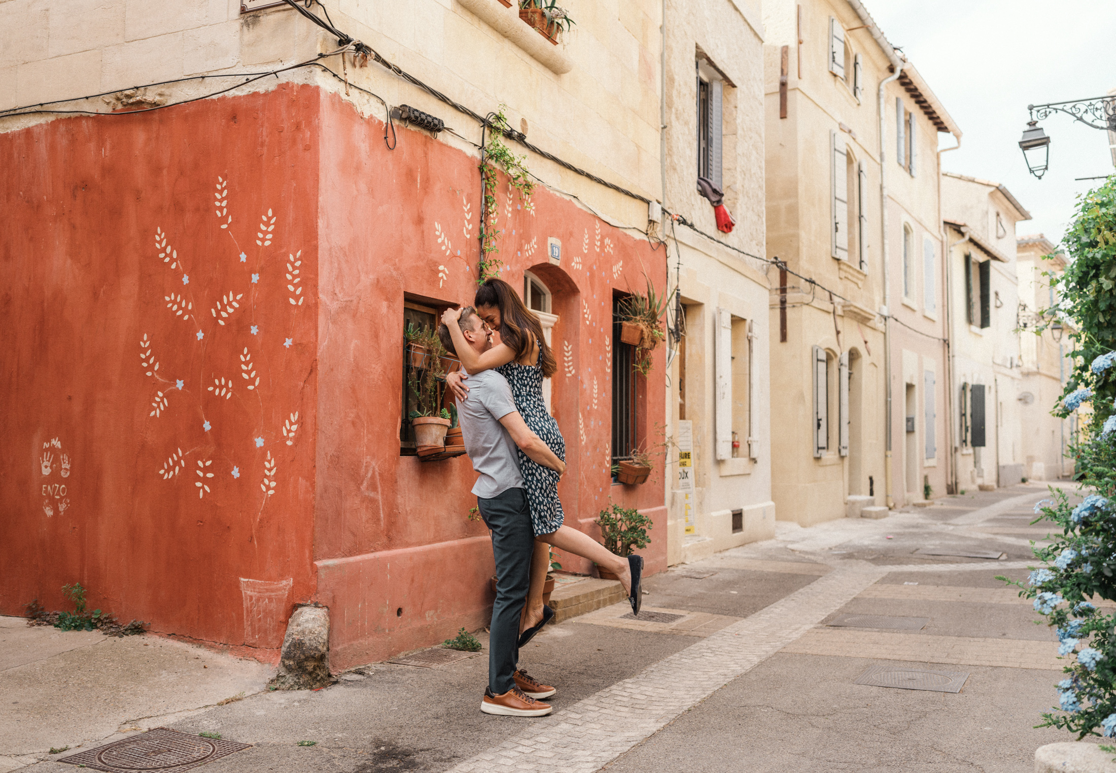 young engaged couple dance and embrace in colorful street in arles france