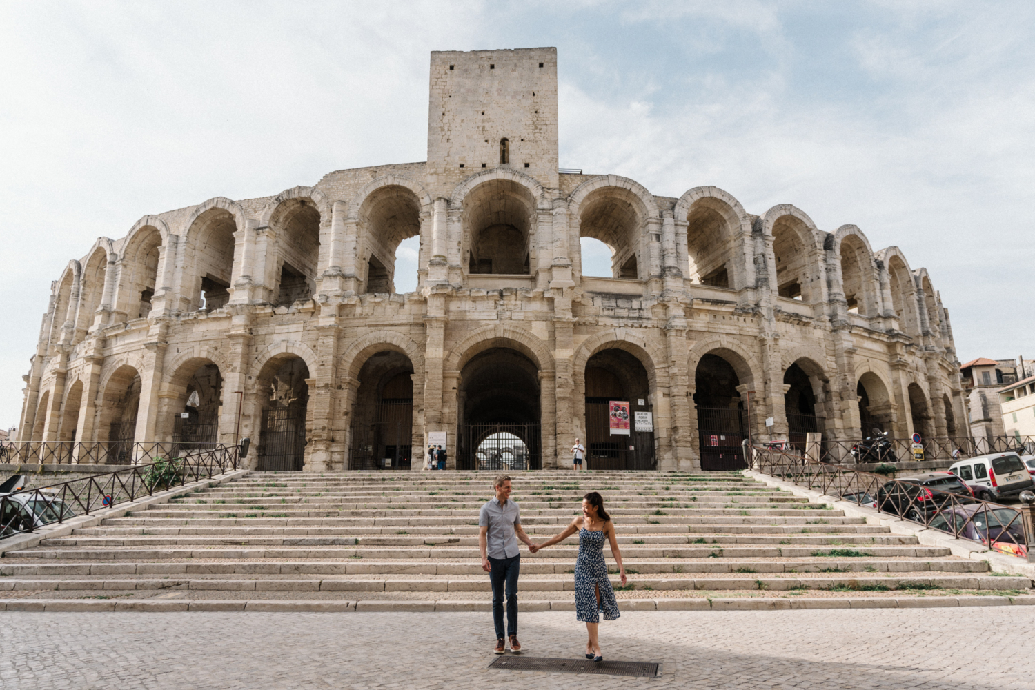 young engaged couple walk at roman amphitheater in arles france