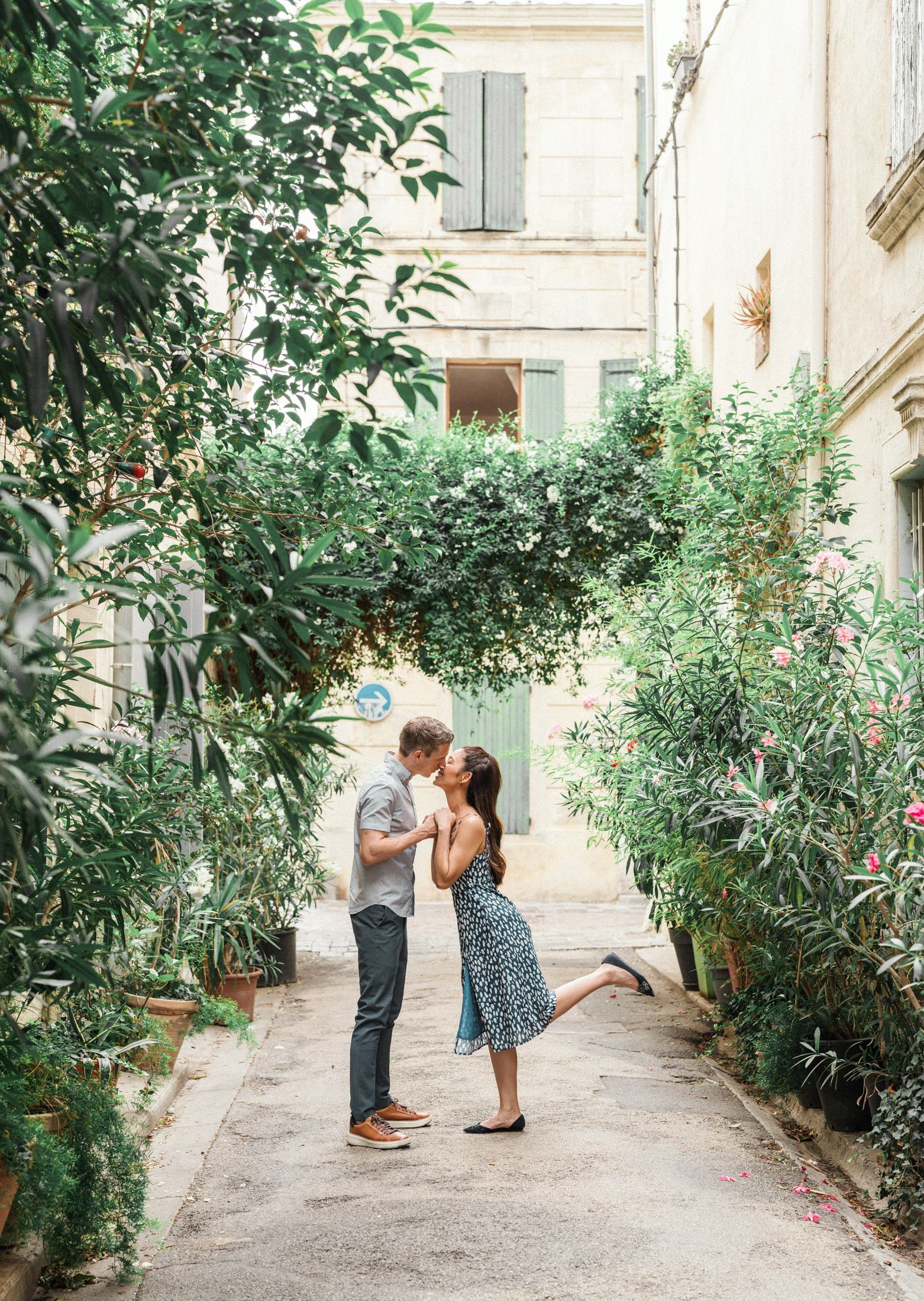 young engaged couple kiss surrounded by plants in arles france during Engagement Photos In Provence