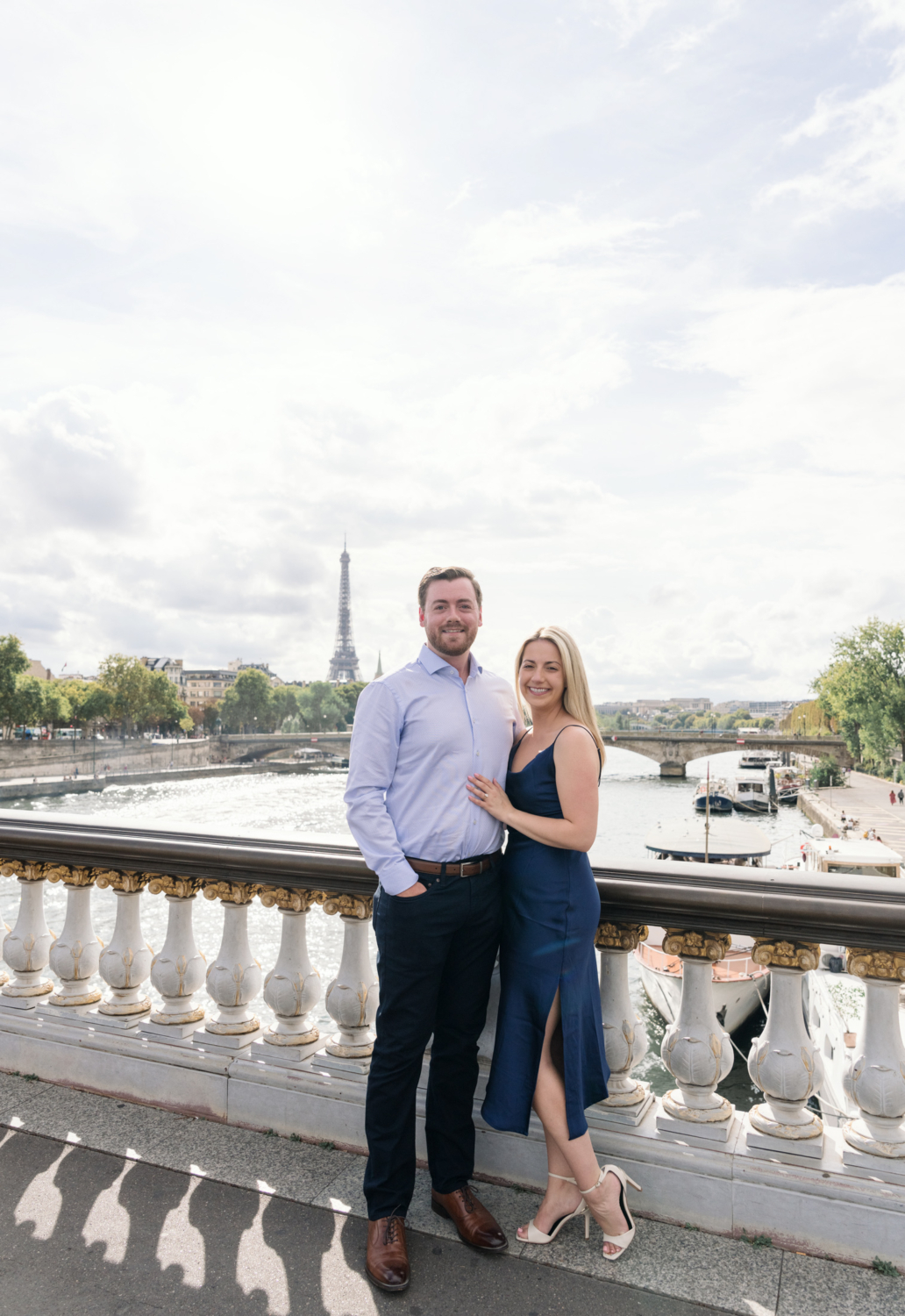 newly engaged couple pose on the bridge of pont alexandre