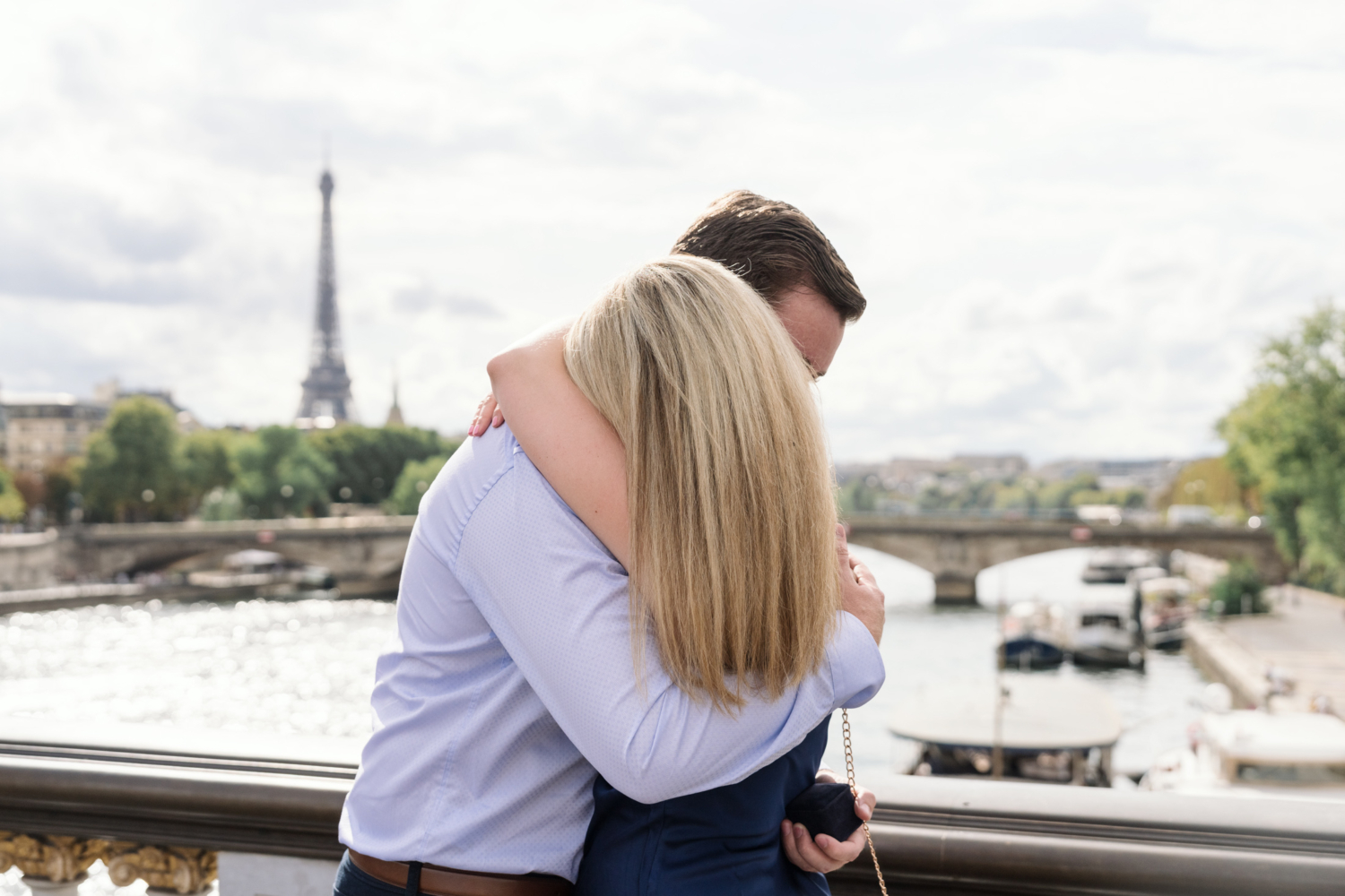 newly engaged couple hug with view of the eiffel tower in paris