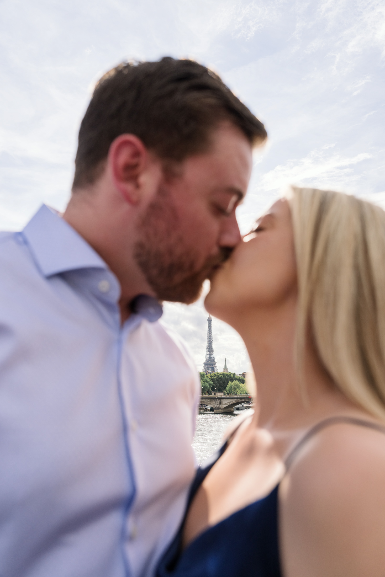 newly engaged couple kiss with eiffel tower in the distance